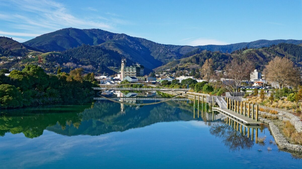 NZ Nelson Panorama of Nelson City reflected in the still waters of the Maitai River